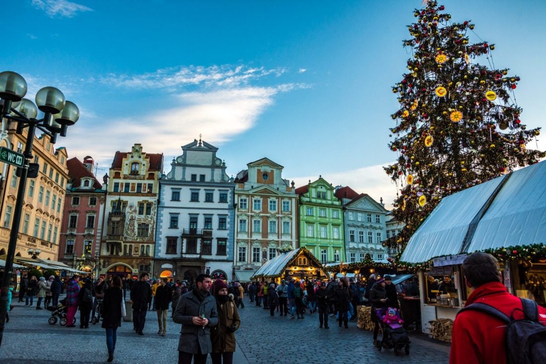 People walking by the Christmas tree in Prague's Old Town Square Christmas Market during the day time
