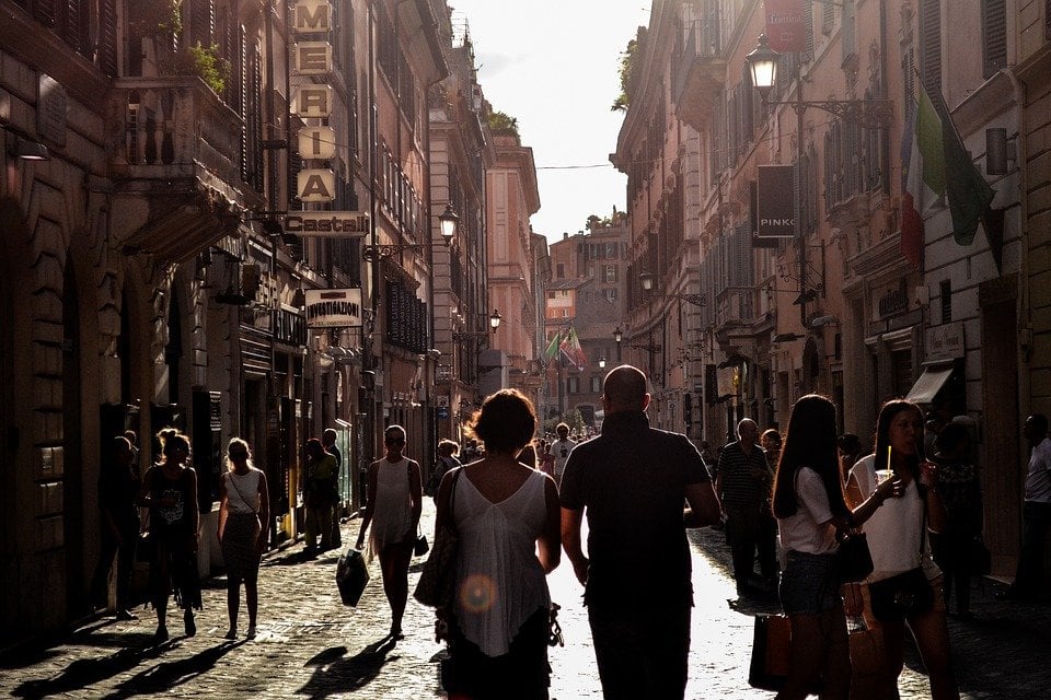 two people walking down a street in naples italy